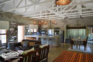 a living room with a couch and a kitchen at Whispering Pines in Dullstroom