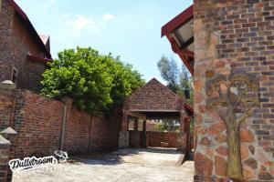 una entrada a un edificio de ladrillo con un árbol en Whispering Pines, en Dullstroom