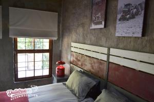 a bedroom with a large bed and two windows at Whispering Pines in Dullstroom