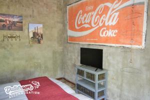 una sala de estar con TV y un cartel de pastel de cocacola en Whispering Pines, en Dullstroom