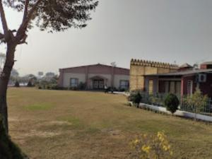 een grote tuin met een gebouw op de achtergrond bij Gargee Surya Vihar Hotel & Resorts,Hotels and Resorts Aurangabad in Aurangābād