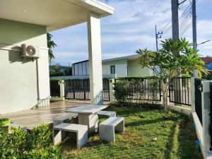 patio ze stołem i ławkami przed budynkiem w obiekcie บ้านคุณพระ แอท รพ.กรุงเทพ w mieście Surat Thani