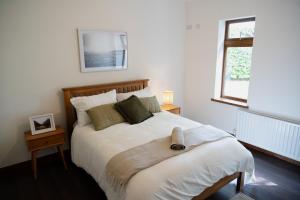 um quarto com uma cama grande com lençóis brancos e uma janela em Rossmore House em Monaghan