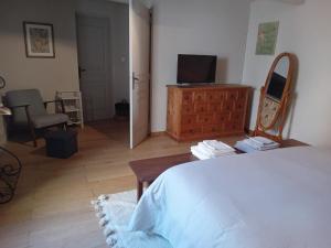 1 dormitorio con cama, tocador y espejo en Le clos de l'Olivelle, en Gallargues-le-Montueux