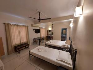 een woonkamer met 2 bedden en een eetkamer bij Angels Resort in Porvorim