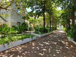 uma passarela num parque com árvores e plantas em Angels Resort em Porvorim