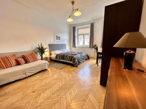 een woonkamer met een bank en een bed bij Pension SKLEP in Praag