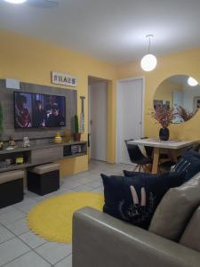 ein Wohnzimmer mit einem Sofa und einem Tisch in der Unterkunft Bate & Volta - Apartamentos com 2 quartos próximo ao SESC Bertioga in Bertioga