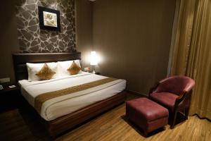 The Vivaan Hotel & Resorts Karnal في كارنال: غرفه فندقيه بسرير وكرسي