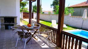 SokolovoにあるВила Нолан с басейн - Villa Nolan with private poolのテーブルと椅子とプールのあるパティオ
