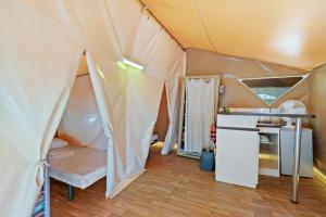 een tent met een bed en een bureau in een kamer bij Camping Le Damier in Pianottoli-Caldarello