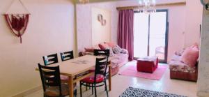 a living room with a table and chairs and a couch at Cozy apartment Maadi Ring road in Cairo