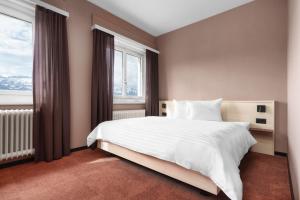 a bedroom with a white bed and a window at Kloster by b-smart in Schaan
