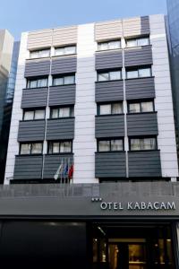 a tall white building with black balconies on it at Hotel Kabacam in İzmir