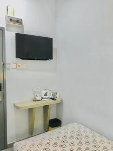 a room with a table and a tv on a wall at Kozi Hotel - Bukit Indah in Johor Bahru