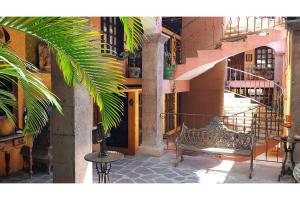 a building with a bench in the middle of a street at Hotel Boutique Posada De Las Flores Loreto in Loreto
