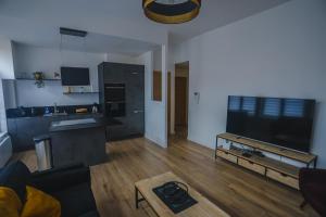 sala de estar con cocina y TV grande en Le moderne 100 mètres de la gare parking gratuit, en Douai