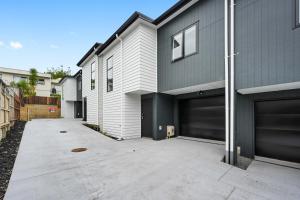 a house with two garage doors and a driveway at New towhouse walk to the hospital & CBD & the Lake in Hamilton