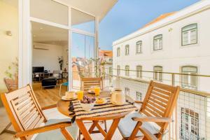 リスボンにあるPríncipe Real Sunny Apartmentの建物のバルコニーにテーブルと椅子