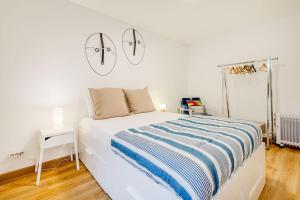 リスボンにあるPríncipe Real Sunny Apartmentの白いベッドルーム1室(ベッド1台、壁に2つの照明付)