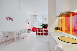 cocina y sala de estar con mesa y sillas en Loft Malinowy by LookAp en Lodz