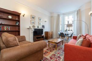 uma sala de estar com um sofá e uma mesa em Adorable 1 bed flat in West Brompton, sleeps 4 em Londres