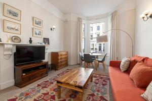 a living room with a couch and a table at Adorable 1 bed flat in West Brompton, sleeps 4 in London