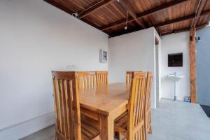 Un comedor con mesa y sillas de madera. en Garvi Villa, en Karangasem