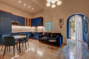 a kitchen with blue cabinets and a table and chairs at PIJU LUX APARTMENTS in Sliema