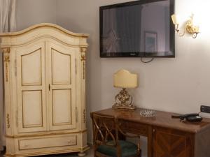 a room with a desk and a tv on the wall at Hotel Serena in Naples