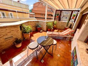 patio al aire libre con mesa y sillas en el balcón en Far Home Gran Vía en Madrid