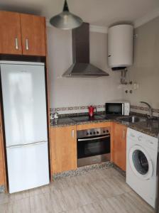 uma cozinha com um frigorífico branco e uma máquina de lavar louça em Apartamento Cruces em El Puerto de Santa Maria