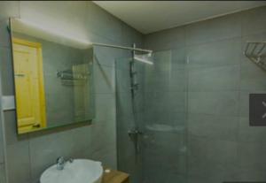 y baño con ducha acristalada y lavamanos. en Didveli gallery bakuriani Room A102, en Bakuriani