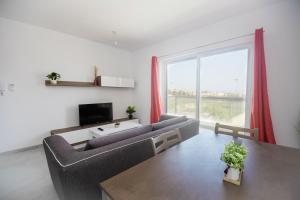 a living room with a couch and a large window at Brewmaster Residence in Is-Swieqi