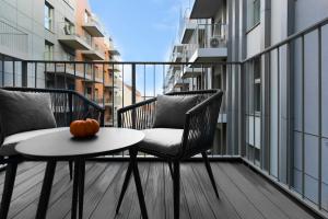 una mesa y sillas en un balcón con una calabaza. en Elite Apartments Grano Residence en Gdansk
