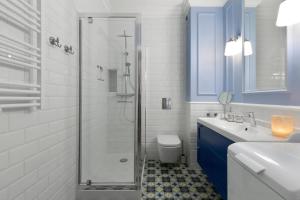 a bathroom with a shower and a sink and a toilet at Elite Apartments Grano Residence in Gdańsk +19 photos