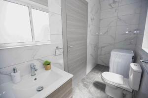 bagno bianco con servizi igienici e lavandino di Brewmaster Residence a Is-Swieqi