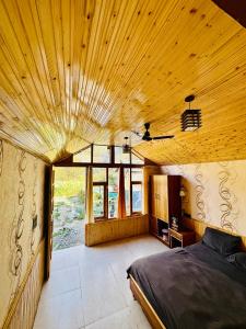 a bedroom with a bed and a wooden ceiling at The Aisling House in Kasol