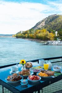 un tavolo blu con sopra del cibo vicino all'acqua di Aquamarina Hotel Visegrád a Visegrád