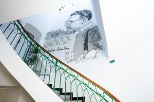 una escalera con un póster de un hombre en la pared en White Wolf House Hostel & Apartments, en Praga