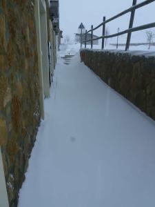 Casa Majo Valdelinares VUTE-23-002 في فالديليناريس: رصيف مغطى بالثلج بجوار جدار