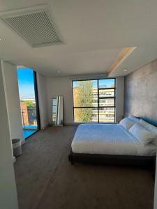 a bedroom with a large bed and large windows at Modern day Homes 3 in Johannesburg