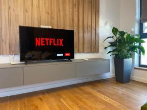 a flat screen tv sitting on top of a entertainment center at UpNorth Home in Bucharest