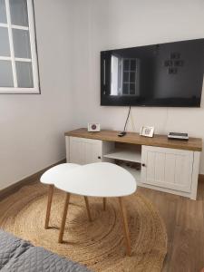 a living room with a table and a white stool at HOUSE SAL Y MAR in Arrieta +8 photos