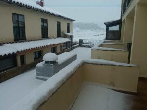 un balcón con nieve en los tejados de los edificios en Casa Majo Valdelinares VUTE-23-002, en Valdelinares