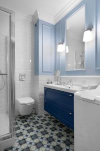 Elite Apartments Grano Residence في غدانسك: حمام مع حوض أزرق ومرحاض