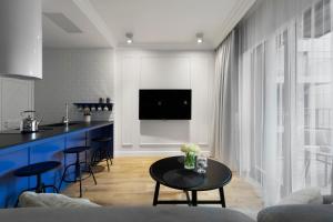 Elite Apartments Grano Residence في غدانسك: مطبخ وغرفة معيشة مع طاولة