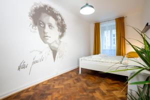 een slaapkamer met een tekening van een vrouw aan de muur bij White Wolf House Hostel & Apartments in Praag