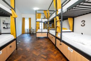 a dorm room with bunk beds in it with a table at White Wolf House Hostel & Apartments in Prague