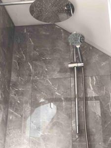 a shower in a bathroom with a marble floor at Lakeside Loft in Hereford